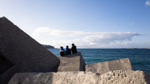 Alí (nombre ficticio) junto a otros compañeros marroquíes, en las escolleras cercanas al puerto de Ceuta, donde tratan de colarse en un barco con destino a la península.