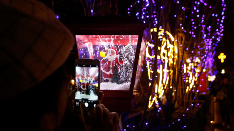 Una mujer toma fotos de una decoración de Santa Claus con su teléfono en la Catedral Xishiku, una iglesia católica sancionada por el gobierno, en la víspera de Navidad en Beijing, China, 24 de diciembre de 2019. REUTERS / Florence Lo