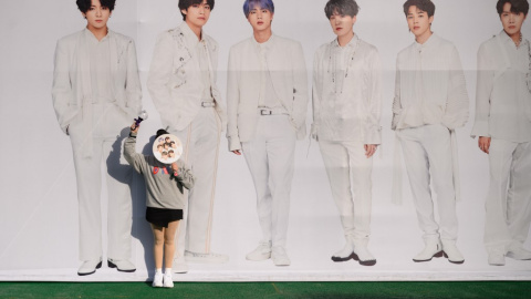 Una fan del grupo coreano de k-pop BTS posa junto a un cartel con los miembros de la banda. - AFP Una fan del grupo coreano de k-pop BTS posa junto a un cartel con los miembros de la banda. - AFP