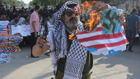 Un palestino quema una bandera de Estados Unidos en una protesta en el paso de Erez contra la decisión de la Administración Trump de suspender la financiación a la UNRWA. - AFP Un palestino quema una bandera de Estados Unidos en una protesta en el paso de Erez contra la decisión de la Administración Trump de suspender la financiación a la UNRWA. - AFP