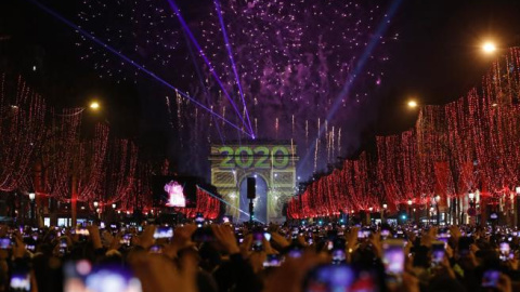 Miles de personas se congregan frente al arco del triunfo en París para celebrar la entrada del año. (Christophe Ena / AP)