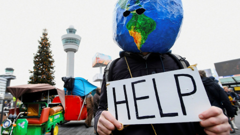 Un manifestante disfrazado de planeta Tierra sujeta un cartel en el que se puede leer "ayuda". REUTERS/Piroschka van de Wouw Un manifestante disfrazado de planeta Tierra sujeta un cartel en el que se puede leer "ayuda". REUTERS/Piroschka van de Wouw