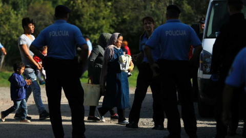 Agentes de la Policía croata escolta na varios migrantes. - REUTERS Agentes de la Policía croata escolta na varios migrantes. - REUTERS
