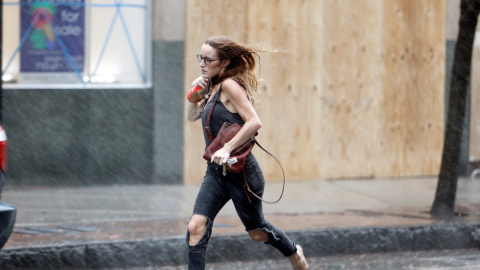 Una mujer corre en el momento del inicio de las lluvias en Wilmington (Carolina del Norte) - REUTERS/Jonathan Drake