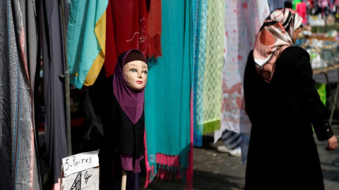 Una mujer con velo pasa junto a una tienda de venta de pañuelos en una imagen de archivo. / REUTERS - FRANCOIS LENOIR Una mujer con velo pasa junto a una tienda de venta de pañuelos en una imagen de archivo. / REUTERS - FRANCOIS LENOIR