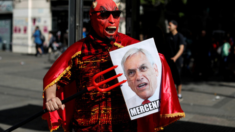 Un manifestante con una pancarta de Sebastián Piñera durante una protesta en Santiago de Chile. - REUTERS Un manifestante con una pancarta de Sebastián Piñera durante una protesta en Santiago de Chile. - REUTERS