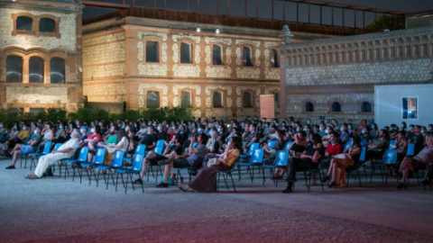 Un grupo de gente disfruta de una película proyectada en el cine de verano de Matadero (Madrid). Un grupo de gente disfruta de una película proyectada en el cine de verano de Matadero (Madrid).