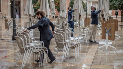 Unos trabajadores de un restaurante del centro de Valencia recogen la terraza. EFE/Biel Aliño Unos trabajadores de un restaurante del centro de Valencia recogen la terraza. EFE/Biel Aliño