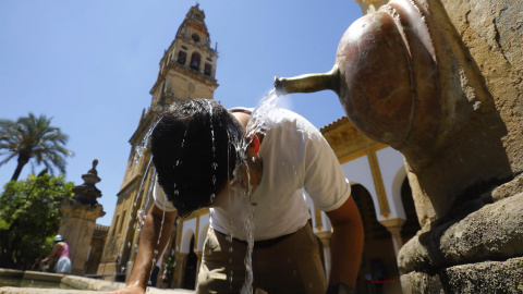 un turista se refresca en una de las fuentes del Patio de los Naranjos de la Mezquita catedral de Córdoba para aliviar las altas temperaturas. un turista se refresca en una de las fuentes del Patio de los Naranjos de la Mezquita catedral de Córdoba para aliviar las altas temperaturas.