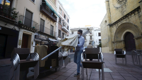 Un trabajador recoge el mobiliario de la terraza de un restaurante en el centro de Córdoba. Un trabajador recoge el mobiliario de la terraza de un restaurante en el centro de Córdoba.