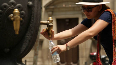 Una persona bebe agua en una fuente de Barcelona para combatir el calor. Una persona bebe agua en una fuente de Barcelona para combatir el calor.