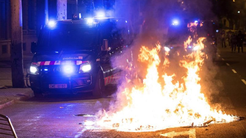 Un furgón de los Mossos d'Esquadra pasa junto al fuego durante los altercados al finalizar la movilización convocada por la ANC y otras entidades soberanistas. - EFE Un furgón de los Mossos d'Esquadra pasa junto al fuego durante los altercados al finalizar la movilización convocada por la ANC y otras entidades soberanistas. - EFE