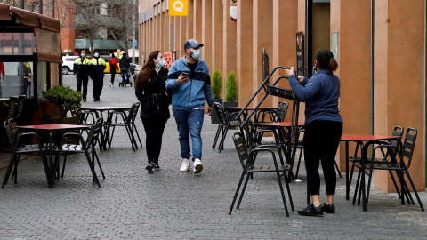 Una camarera prepara la terraza del restaurante donde trabaja para atender a sus clientes en L'Hospital de Llobregat. Una camarera prepara la terraza del restaurante donde trabaja para atender a sus clientes en L'Hospital de Llobregat.