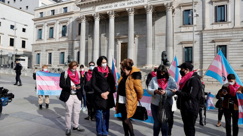 Miembros de la Federación Plataforma Trans y de otros colectivos se congregan a las puertas del Congreso este jueves para expresar su indignación por el bloqueo de la ley trans y anunciar una posible huelga de hambre si no se tramita esa norma. Miembros de la Federación Plataforma Trans y de otros colectivos se congregan a las puertas del Congreso este jueves para expresar su indignación por el bloqueo de la ley trans y anunciar una posible huelga de hambre si no se tramita esa norma.