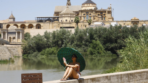 11/07/2022-Una turista se protege del calor con un paraguas y un abanico a la orilla del río Guadalquivir cerca de la Mezquita-Catedral de Córdoba este lunes cuando la Agencia Estatal de Meteorología (Aemet), ha alertado que la segunda ola de calor de 11/07/2022-Una turista se protege del calor con un paraguas y un abanico a la orilla del río Guadalquivir cerca de la Mezquita-Catedral de Córdoba este lunes cuando la Agencia Estatal de Meteorología (Aemet), ha alertado que la segunda ola de calor de