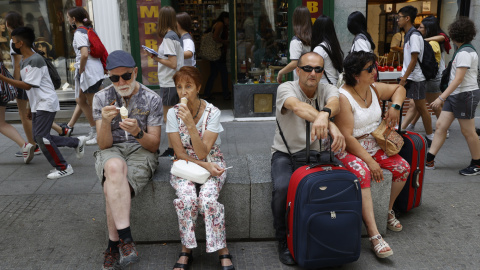 Varios turistas descansan en un banco de granito en el centro de Madrid. EFE/ Mariscal Varios turistas descansan en un banco de granito en el centro de Madrid. EFE/ Mariscal