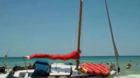 Un velero encallado a la orilla de la playa Un velero encallado a la orilla de la playa
