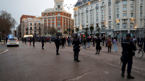 Efectivos policiales vigilan a asistentes a una sentada improvisada en la plaza de Neptuno de Madrid. Efectivos policiales vigilan a asistentes a una sentada improvisada en la plaza de Neptuno de Madrid.