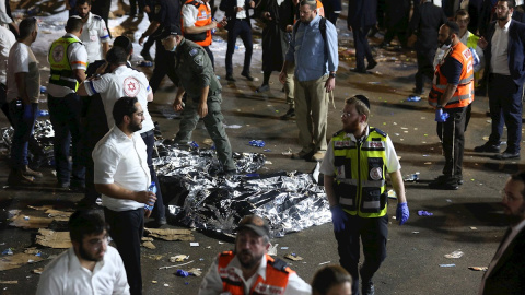 Los servicios médicos atienden a heridos, con los cuerpos de los fallecidos tapados en el suelo, tras la tragedia ocurrida durante la festividad del Lag Baomer, en el norte de Israel. Los servicios médicos atienden a heridos, con los cuerpos de los fallecidos tapados en el suelo, tras la tragedia ocurrida durante la festividad del Lag Baomer, en el norte de Israel.