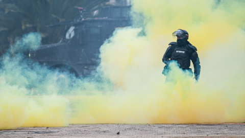 28/04/2022-Un agente de la policía antidisturbios se para entre el humo durante una protesta contra el gobierno del presidente Iván Duque el 28 de abril de 2022 28/04/2022-Un agente de la policía antidisturbios se para entre el humo durante una protesta contra el gobierno del presidente Iván Duque el 28 de abril de 2022
