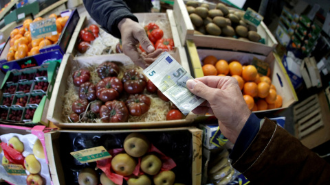Un cliente paga con un billete de 5 euros en un puesto de fruta de un mercado en Niza (Francia). REUTERS/Eric Gaillard Un cliente paga con un billete de 5 euros en un puesto de fruta de un mercado en Niza (Francia). REUTERS/Eric Gaillard