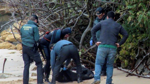 La Guardia Civil junto a uno de los dos cadáveres más hallados de los ocupantes de la patera que naufragó el pasado lunes en la playa de Caños de Meca (Cádiz), mientras que la Policía ha detenido al patrón de la embarcación y a su ayudante, quiene La Guardia Civil junto a uno de los dos cadáveres más hallados de los ocupantes de la patera que naufragó el pasado lunes en la playa de Caños de Meca (Cádiz), mientras que la Policía ha detenido al patrón de la embarcación y a su ayudante, quiene