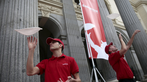 Los trabajadores de Telepizza lanzan la masa al aire en una demostración en la Bolsa de Madrid el primer día de cotización de la empresa.. REUTERS/Andrea Comas Los trabajadores de Telepizza lanzan la masa al aire en una demostración en la Bolsa de Madrid el primer día de cotización de la empresa.. REUTERS/Andrea Comas