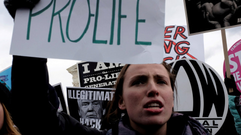 A fondo, una contramanifestante sostiene un cartel anti Trump. / Reuters A fondo, una contramanifestante sostiene un cartel anti Trump. / Reuters