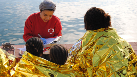 Una imagen de archivo niñas menores a su llegada a Melilla, siendo asistidas por una trabajadora de Cruz Roja tras ser rescatadas de una patera. IRENE QUIRANTE