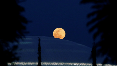 La luna llena se levanta detrás de la biblioteca de la Universidad de Chipre en Nicosia | REUTERS/ Yiannis Kourtoglou