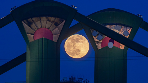 La Super Luna se puede ver detrás de los pilares del puente Floesserbruecke en Frankfurt am Main, Alemania occidental | AFP/ Frank Rumpenhorst