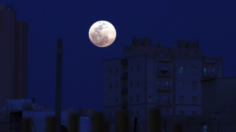 La luna llena se levanta sobre la capital kuwaití, Ciudad de Kuwait el 19 de febrero de 2019 | AFP/ Yasser Al-Zayyat