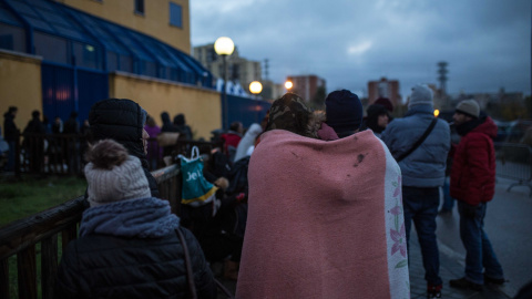 Una pareja de solicitantes de asilo se abriga con una manta mientras hace cola para pedir cita en la comisaría de Aluche. Algunos llevan 48 horas esperando su turno bajo el frío y la lluvia. JAIRO VARGAS Una pareja de solicitantes de asilo se abriga con una manta mientras hace cola para pedir cita en la comisaría de Aluche. Algunos llevan 48 horas esperando su turno bajo el frío y la lluvia. JAIRO VARGAS