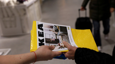 Un trabajador de Ikea entrega un catálogo a un cliente a la entrada de una de sus tiendas en Madrid. REUTERS/Susana Vera Un trabajador de Ikea entrega un catálogo a un cliente a la entrada de una de sus tiendas en Madrid. REUTERS/Susana Vera
