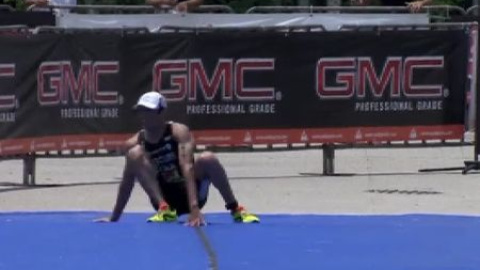 Un triatleta se queda sin fuerzas en la línea de meta Un triatleta se queda sin fuerzas en la línea de meta