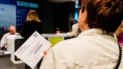 Una mujer hace cola en una oficina de correos para depositar su voto. | EFE Una mujer hace cola en una oficina de correos para depositar su voto. | EFE