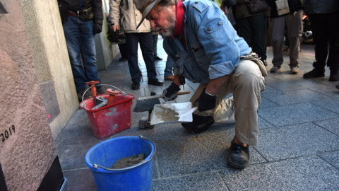 El artista alemán Gunter Demmig instalando una de las piedras de la Memoria en Madrid este viernes.- FERNANDO SÁNCHEZ El artista alemán Gunter Demmig instalando una de las piedras de la Memoria en Madrid este viernes.- FERNANDO SÁNCHEZ