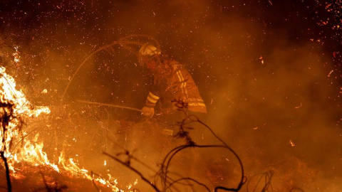 LABARES (ASTURIAS), 03/03/2019.- Los bomberos intentan sofocar el incendio que se ha producido hoy en los alrededores de Labares. Un total de 77 incendios se encuentran activos en Asturias, contra los que luchan unas 200 personas, a las que se sumarán ma