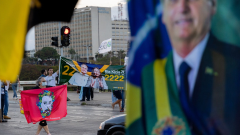 Partidarios del actual presidente Bolsonaro y del exjefe de Estado Lula da Silva promocionan a sus candidatos con banderas y carteles frente a los automovilistas en un semáforo en rojo