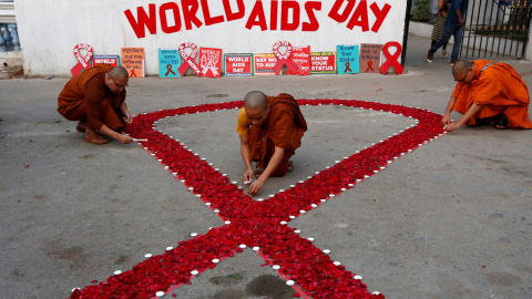 Los monjes budistas encienden velas durante una campaña de sensibilización sobre el VIH / SIDA con motivo del Día Mundial del SIDA en Calcuta.