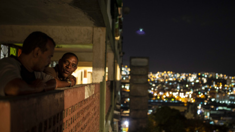 Dos vecinos de uno de los bloques del barrio 23 de Enero de Caracas conversan durante la noche.- JAIRO VARGAS Dos vecinos de uno de los bloques del barrio 23 de Enero de Caracas conversan durante la noche.- JAIRO VARGAS