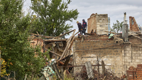 Ciudadanos limpian los escombros de un edificio dañado por los bombardeos en la aldea de Ruski Tyshky del área de Kharkiv. Ciudadanos limpian los escombros de un edificio dañado por los bombardeos en la aldea de Ruski Tyshky del área de Kharkiv.
