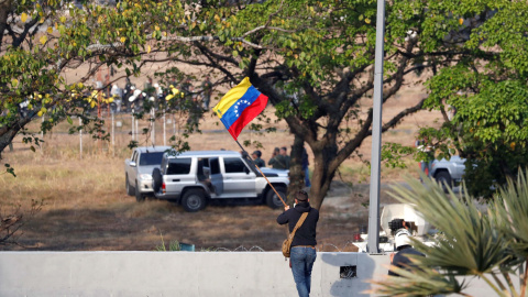Un hombre ondea una bandera venezolana cerca de la base aérea del Generalísimo Francisco de Miranda en Caracas. REUTERS/Carlos Garcia Rawlins