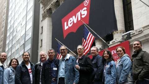 El equipo directivo de la marca de topa vaquera Levi Strauss posa delante del edificio de la Bolsa de Nueva York (NYSE, según sus siglas en inglés), en el primer día de cotización de la firma. REUTERS/Brendan McDermid