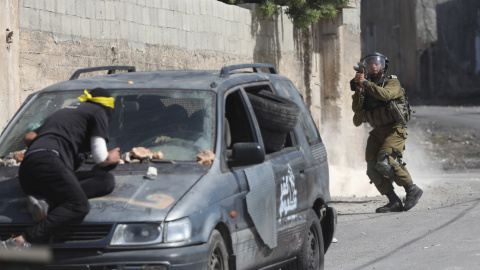 Un soldado israelí apunta su arma durante enfrentamientos con manifestantes palestinos. Un soldado israelí apunta su arma durante enfrentamientos con manifestantes palestinos.