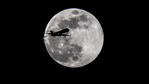 Un avión pasa frente a la luna llena durante el primer día de primavera en Fráncfort (Alemania). - EFE/ Armando Babani