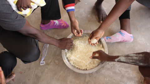 Un grupo de refugiados del campamento libio de Sbaa, compartiendo un cuenco de arroz — MSF Un grupo de refugiados del campamento libio de Sbaa, compartiendo un cuenco de arroz — MSF