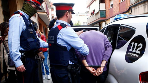 Mossos d'Esquadra custodian a uno de los dos detenidos en Cornellà de Llobregat. EFE Mossos d'Esquadra custodian a uno de los dos detenidos en Cornellà de Llobregat. EFE