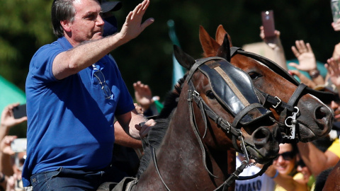 El presidente de Brasil, Jair Bolsonaro, monta a caballo y saluda a sus simpatizantes, en una manifestación en su favor en Brasilia. REUTERS/Ueslei Marcelino El presidente de Brasil, Jair Bolsonaro, monta a caballo y saluda a sus simpatizantes, en una manifestación en su favor en Brasilia. REUTERS/Ueslei Marcelino