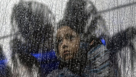 Una niña centroamericana que viaja en una caravana de migrantes, toma un autobús fuera de un refugio temporal en el este de Tijuana, México, el 6 de diciembre de 2018 | Guillermo Arias/AFP Una niña centroamericana que viaja en una caravana de migrantes, toma un autobús fuera de un refugio temporal en el este de Tijuana, México, el 6 de diciembre de 2018 | Guillermo Arias/AFP